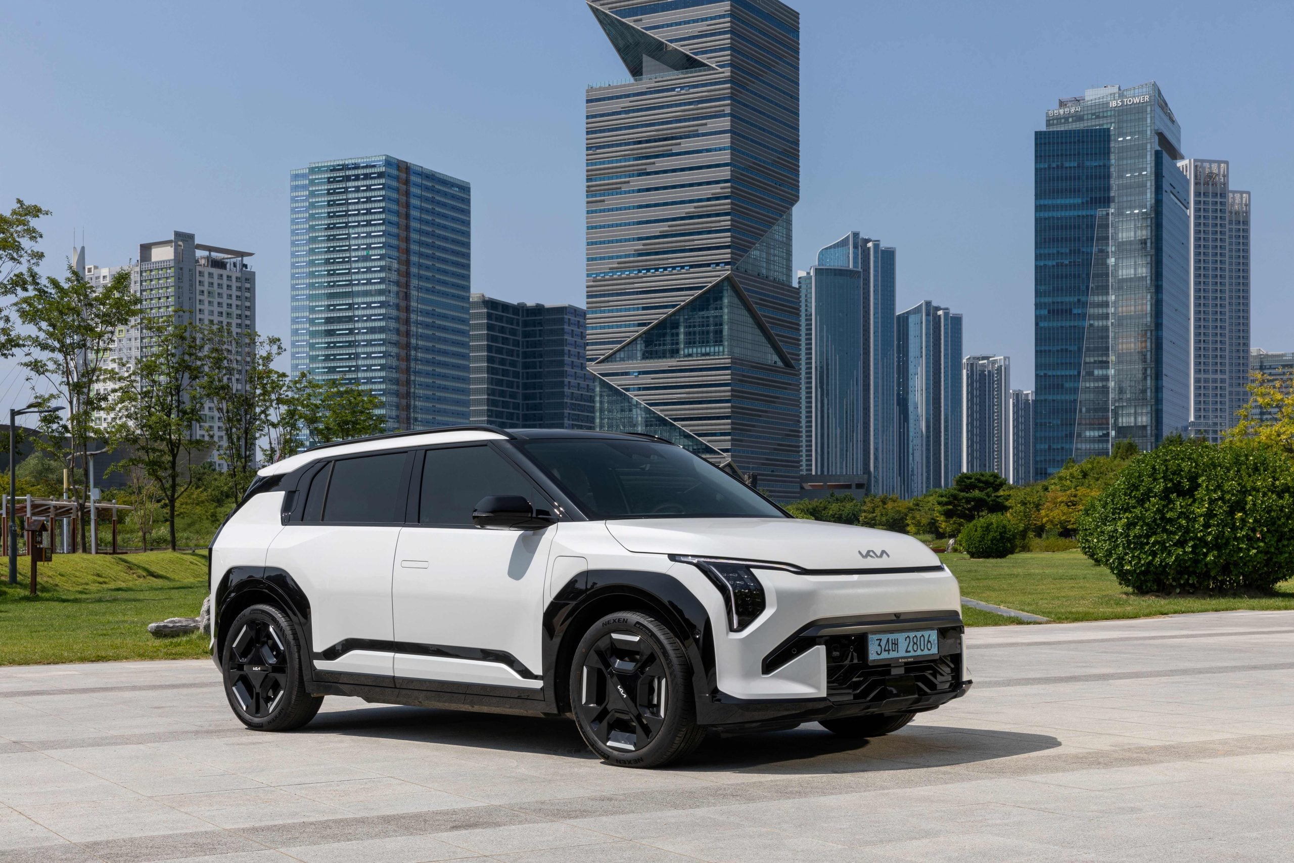 Kia EV3 parked up in front of a zany building.