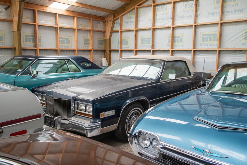 Cadillac Eldorado parked in garage among Fords
