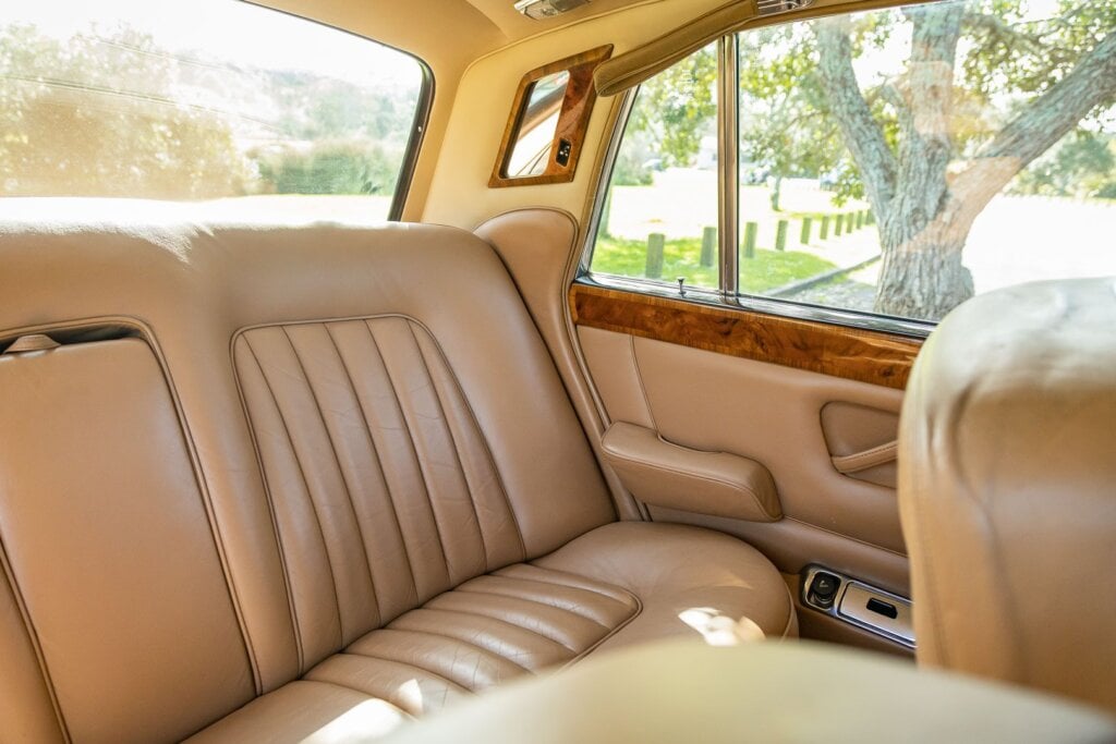 Leather rear seat space inside the 1970 Silver Shadow. Passenger mirror and pull down leather handle