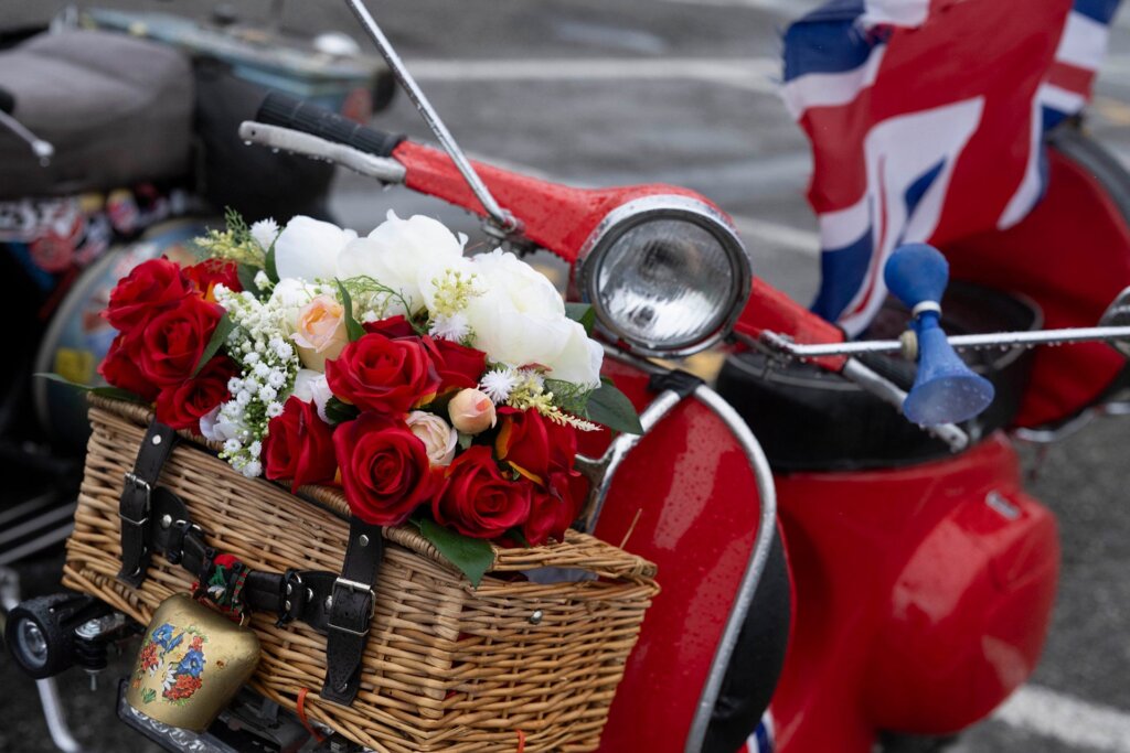 Roses adorn a rose-red Vespa.