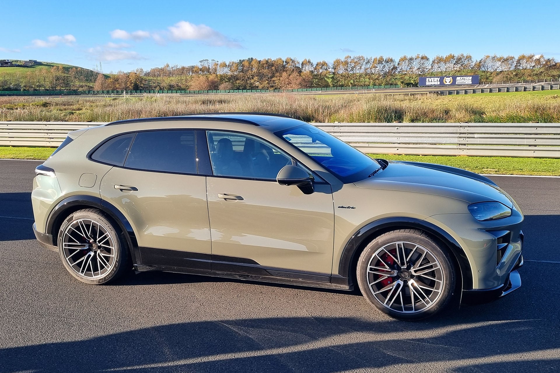 Porsche Cayenne electric in green under blue skies