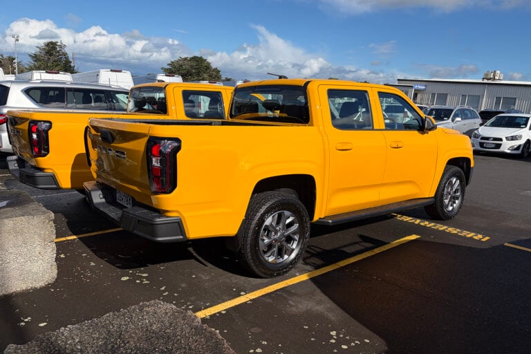 Two yellow JMC Grand Avenue utes from the rear in an Auckland holding yard