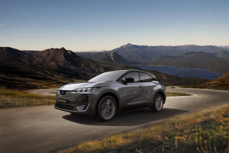 grey Subaru o country road in front of mountains