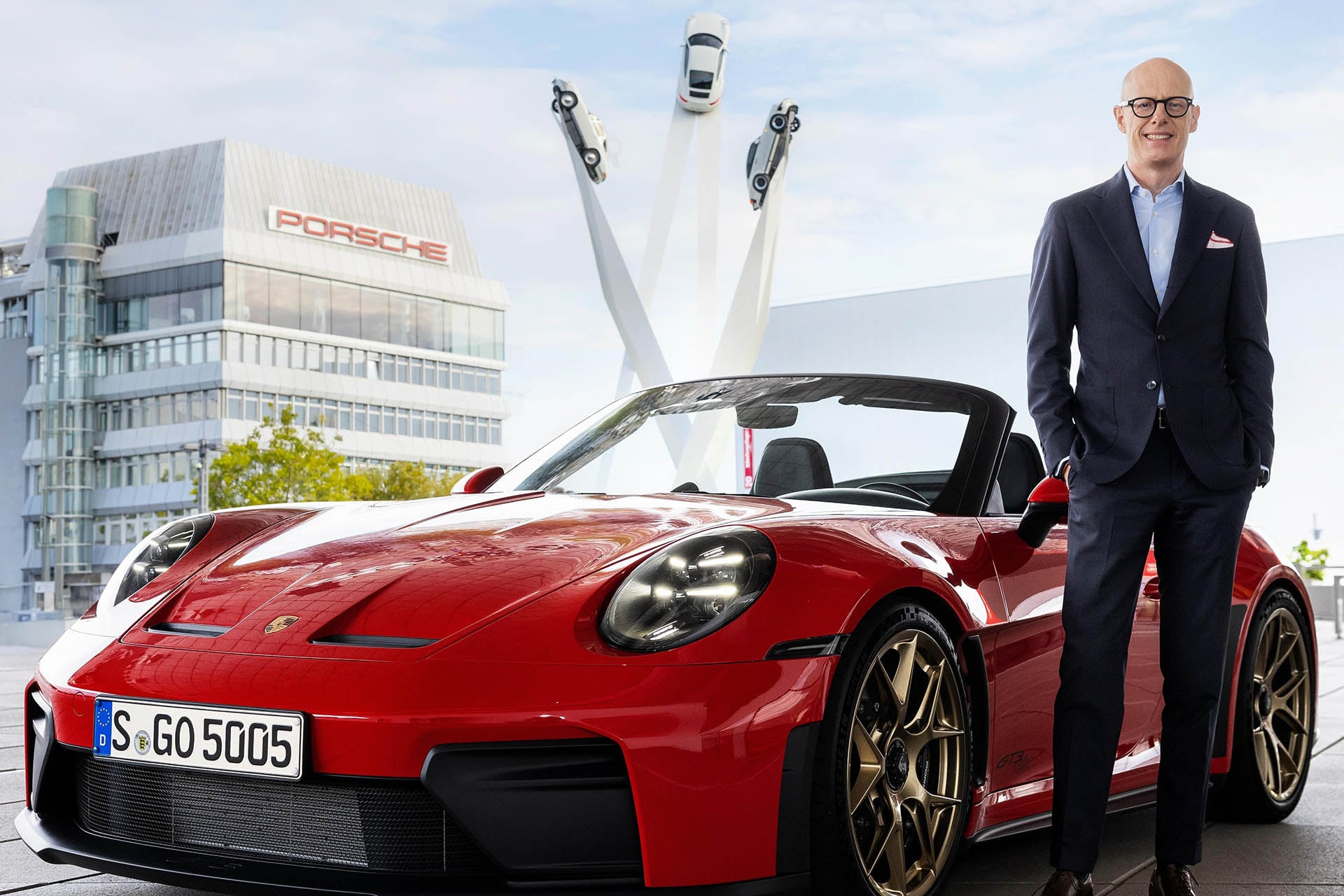 bald guy next to red 911