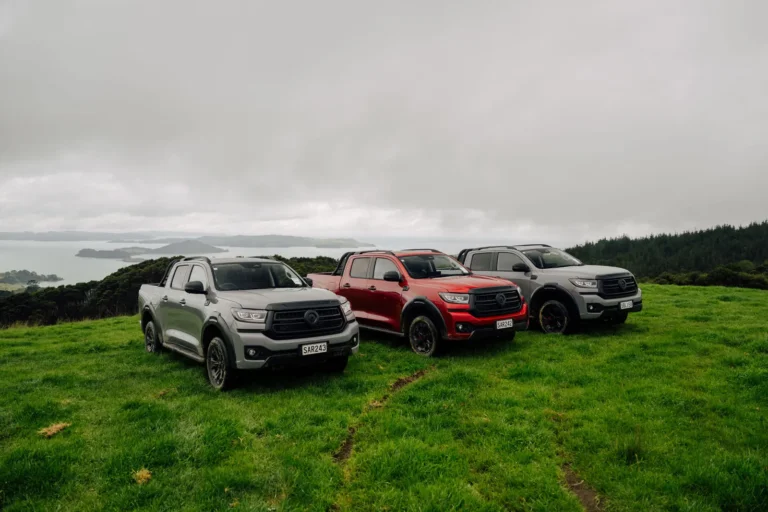 Three GWM Cannon Hi4-T PHEV utes parked on a coastal hilltop
